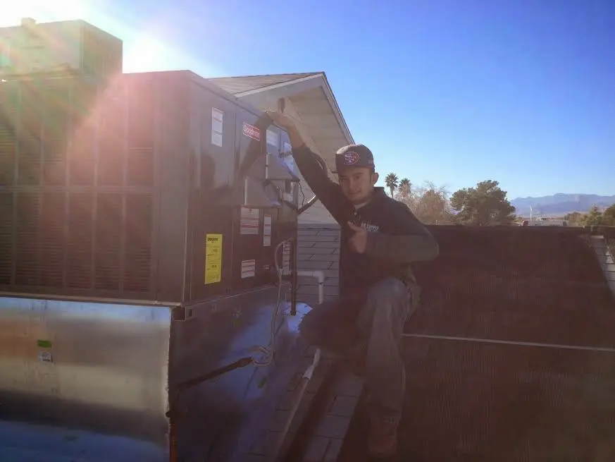 HVAC technician performing AC Tune-Up on a rooftop unit in Calverton